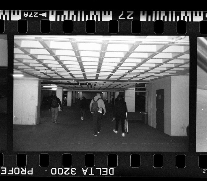 close-up of people walking in a car park taken on film