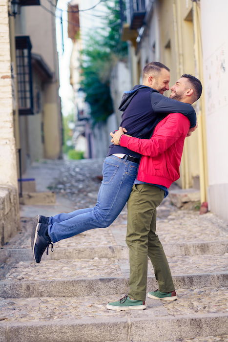 Engagement photography image of a gay couple in a fun and romantic moment in the street