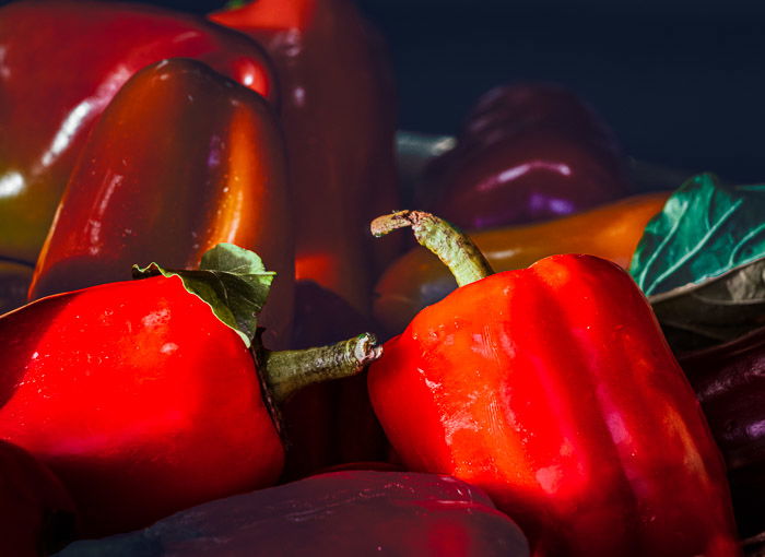 Bushels of red peppers bathed in sunlight at a farmer's market after photoshop selective color