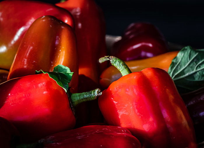 Bushels of red peppers bathed in sunlight at a farmer's market before photoshop selective color