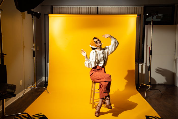 A model posing against a large yellow background