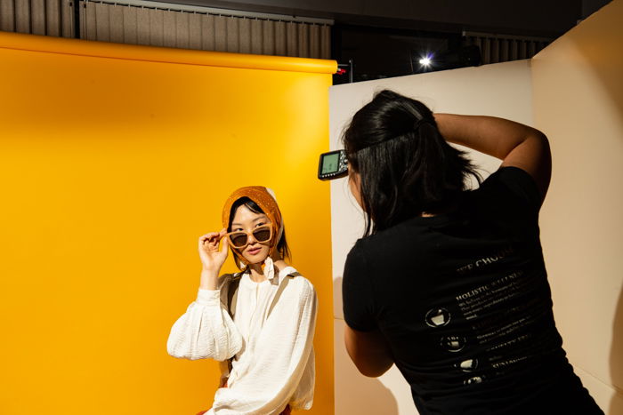 A female photographer taking photos of a model in a studio