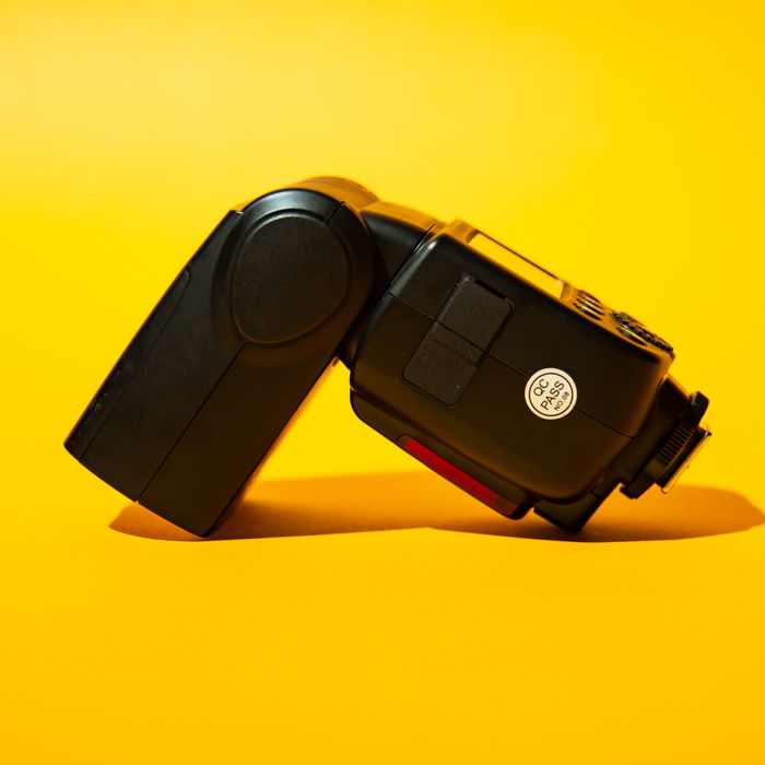 A speedlight against a yellow background