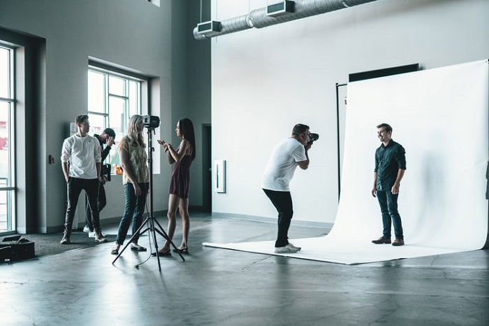 model posing in a studio in front a photographer