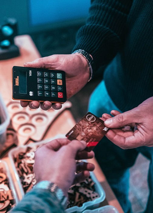 VISA credit card being handed over to a man holding a credit card reader