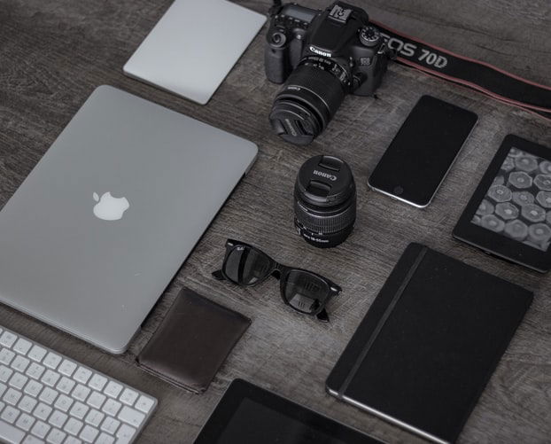 camera and lens surrounded by useful photography tools 