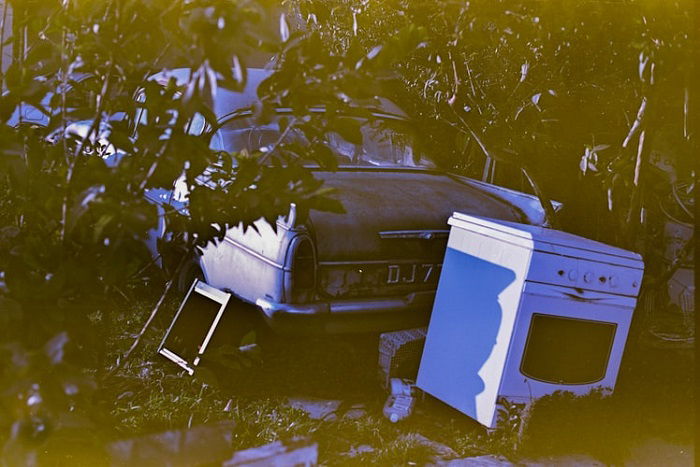 photograph of a classic car and oven shot on expired film with a yellow-green hue