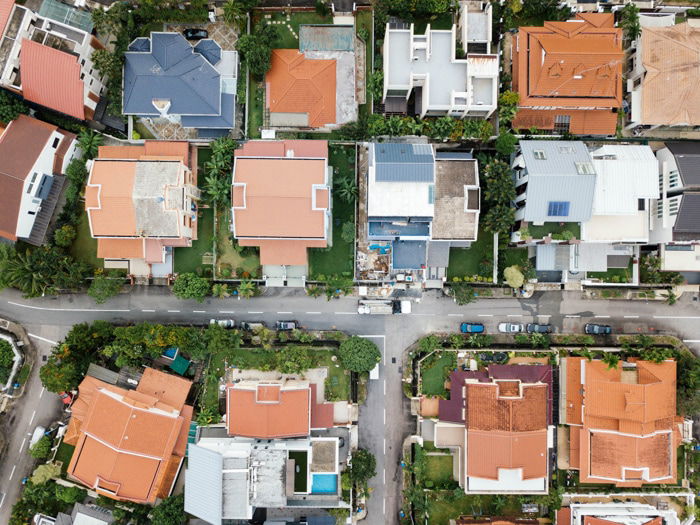 Overhead aerial view showing roofs and yards of houses, and streets in a niegbourhood shot by a real estate photographer