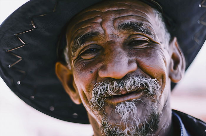 Close-up portrait of a man with a hat photographed with side light