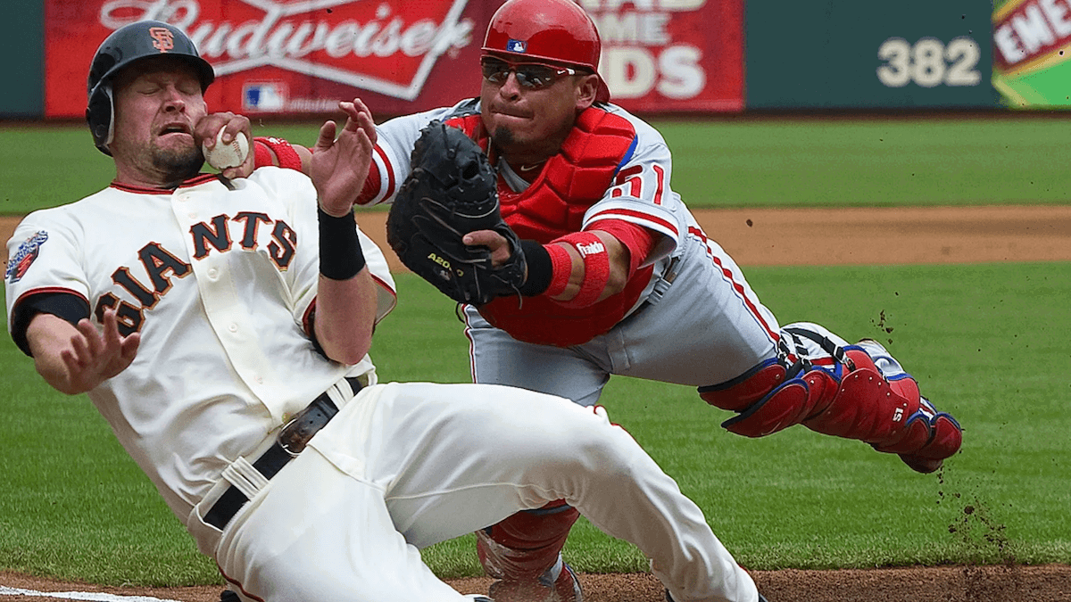 A baseball player being tagged out at home plate by a catcher taken by one of the best sports photographers Brad Mangin