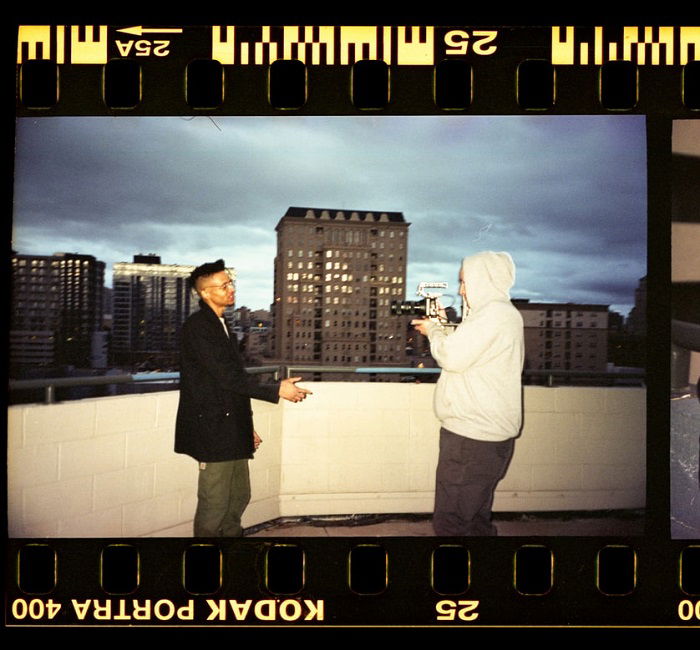 film of a photographer shooting a model against a city sky-rise