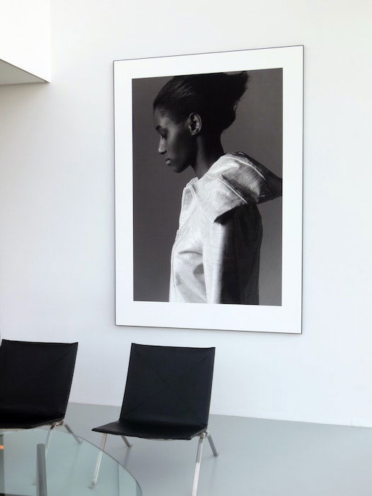 An enlarged black and white photo of a woman framed and hung on a living room wall