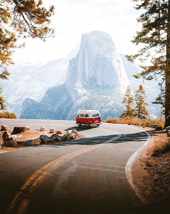 photo of a a van driving through snow capped mountains