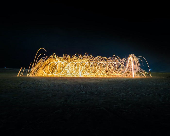 Light painting at night with orange light creating an effect of fire