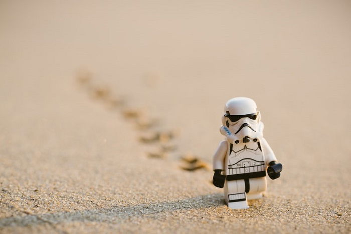 miniature photography of a stormtrooper trekking through sand