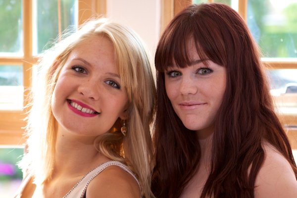 photo of two women taken indoors with windows in the background