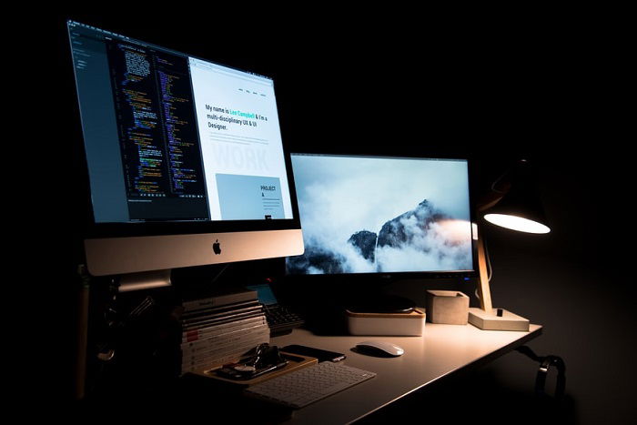 imac on a desk beside a lamp