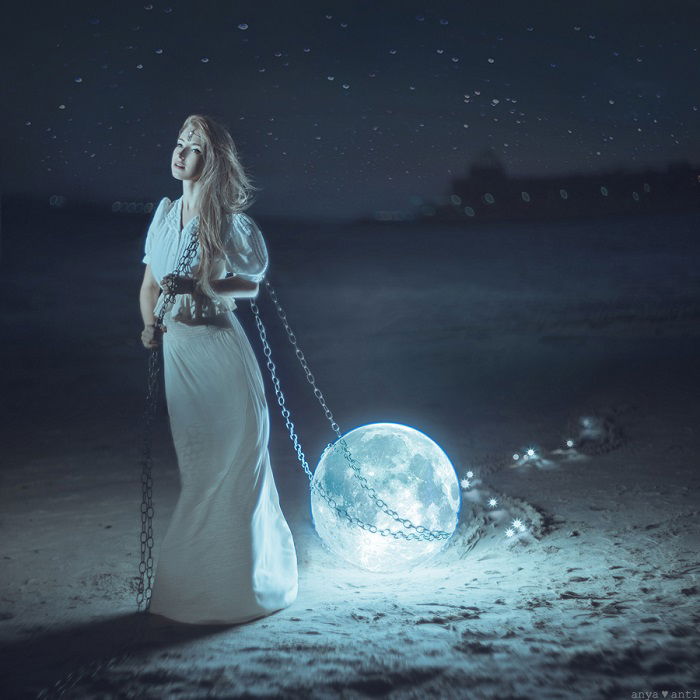 image of a woman dragging the moon behind her using a chain with cool blue tones