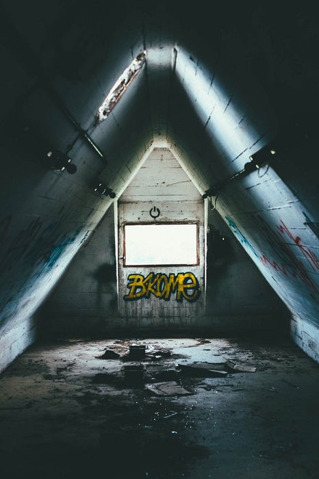 sunlight shining through a skylight in an abandoned attic