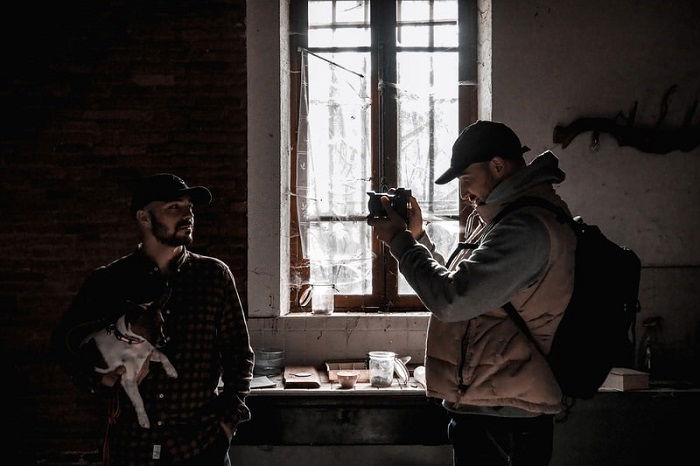 photographer taking a picture of a man holding a dog