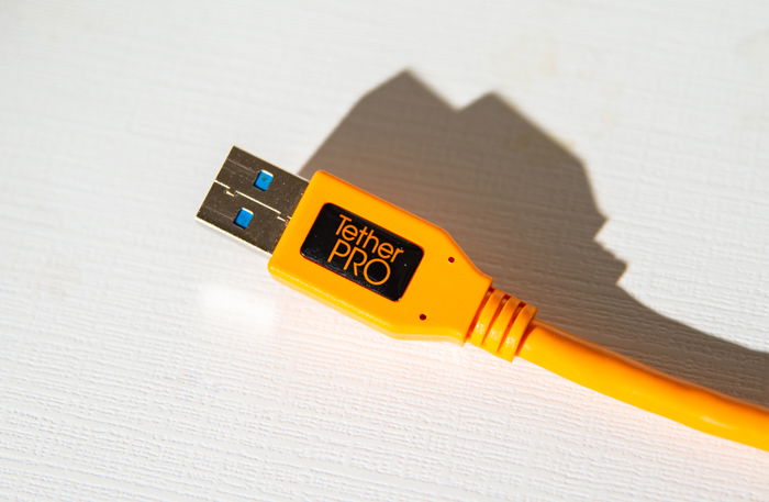 a closeup of a orange tethering cable