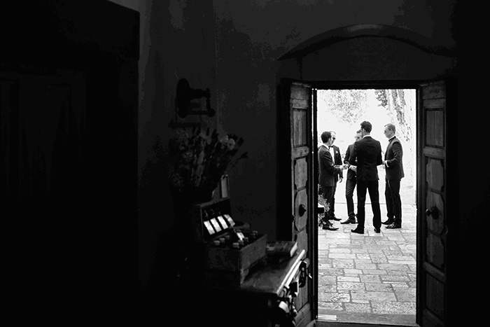 groomsmen picture idea: a black and white image of groomsmen framed in an old doorway