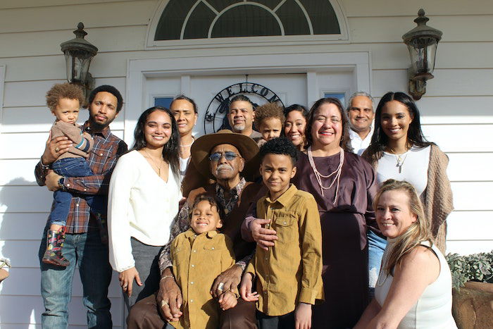 generational photo: a family portrait in front of their house