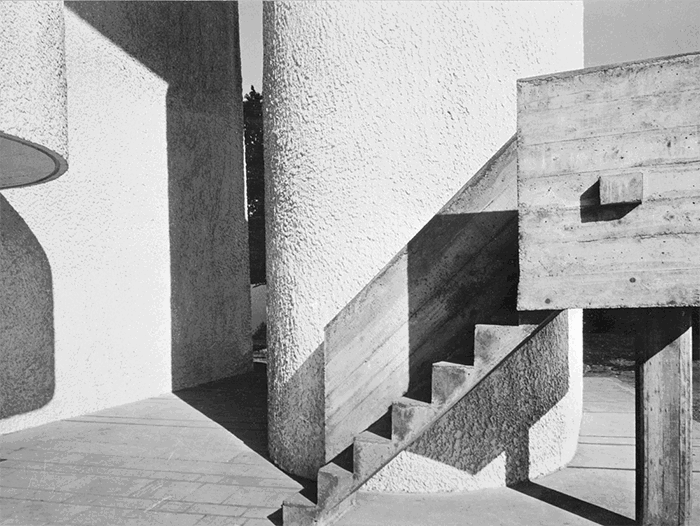 Black and white photo of shadows cast from stairs and a pilar as a famous architectural photography example of form and light by Lucien Herve