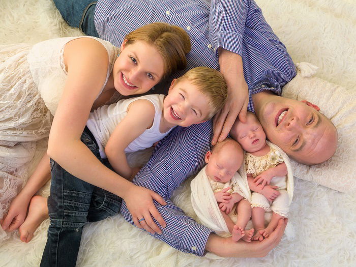 newborn twins photo idea: mum dad and older brother pose with newborn twins