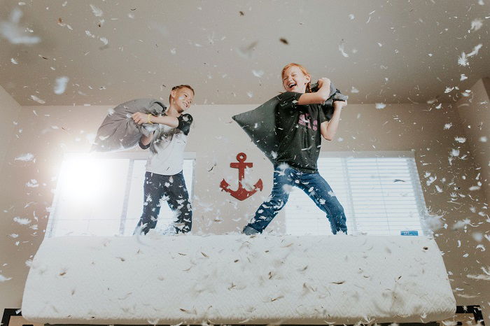 photo ideas for siblings: siblings having a pillow fight