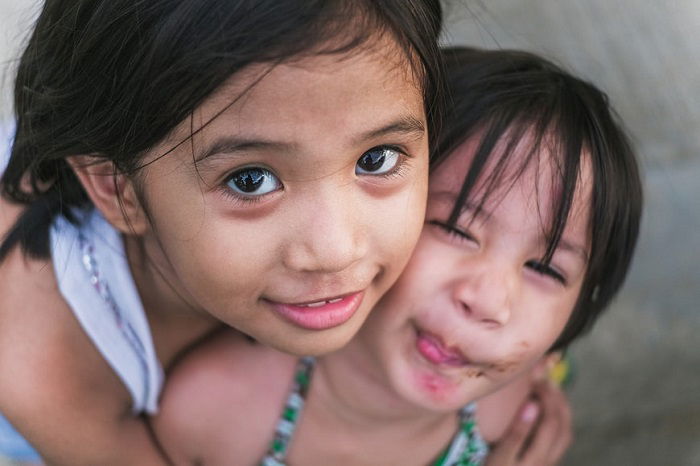 photo ideas for siblings: siblings in a unique candid pose 