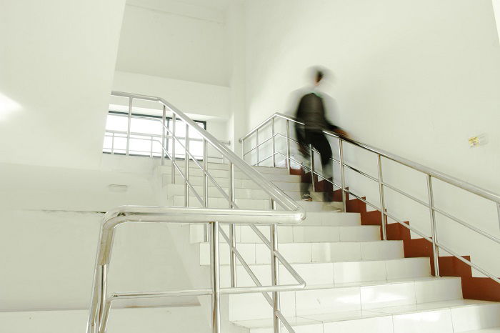 staircase photography idea: motion blur of a person walking down a white staircase