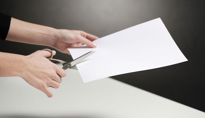 diy light reflector: A person cutting a white piece of paper