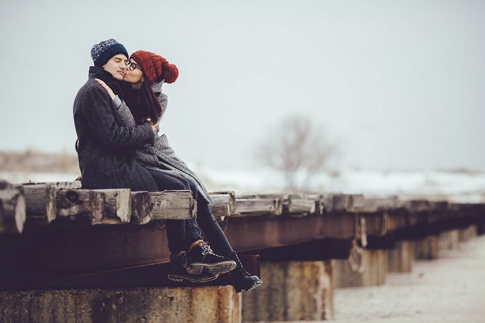 a woman gives her boyfriend a kiss on the cheek 