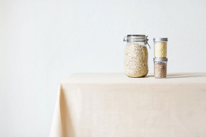 Dried food in glass jars on a plain food photography prop tablecloth