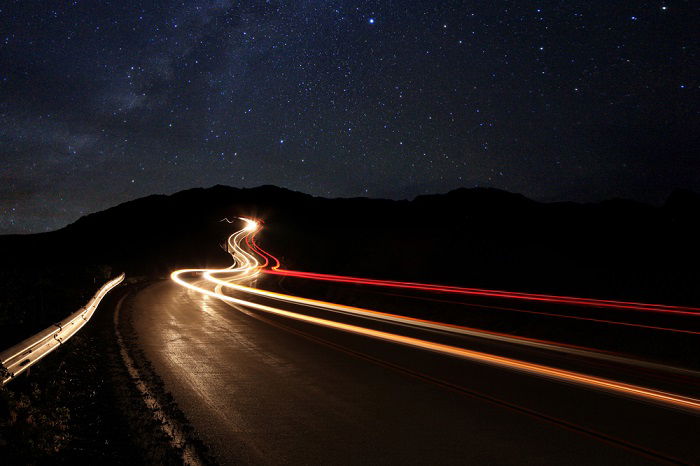 using a time-lapse calculator for time-lapse photos: light streaks from moving cars illuminate a dark road during the night