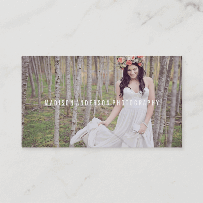 photography business card designs where a bride is holding her dress in a forest