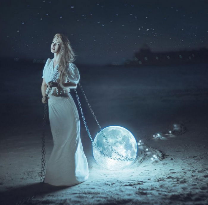 Surreal picture of woman in white dress dragging the moon behind her