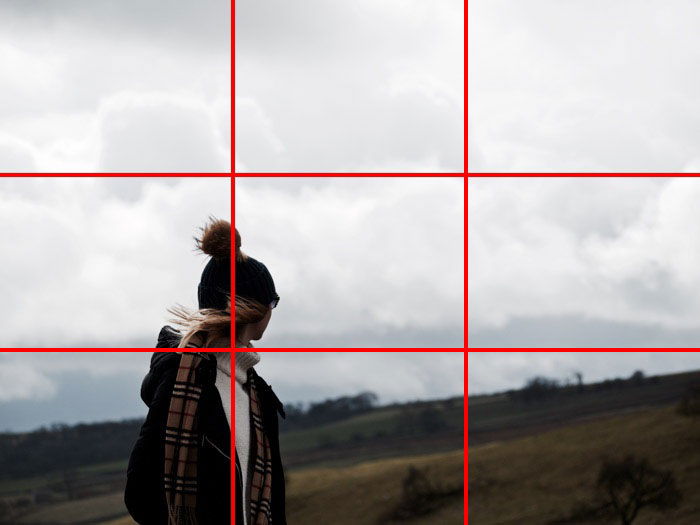 A person walking with the photo divided into six squares. 