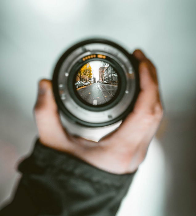 Hand holding a lens not attached to a camera