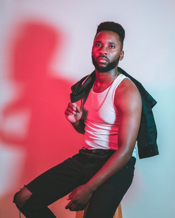 male model in studio posing with jacket over shoulder