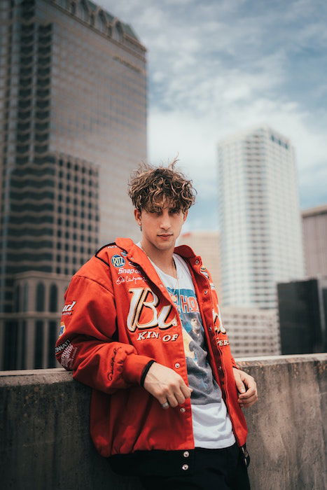 man leaning on wall outside in a city