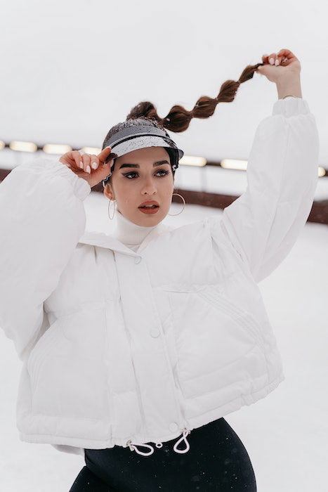 Woman playing with her hat and hair as an example of model poses