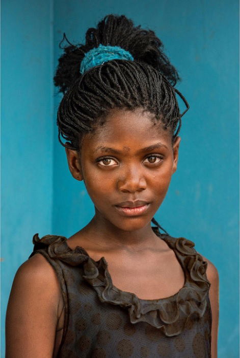 portrait of young girl in front of blue wall