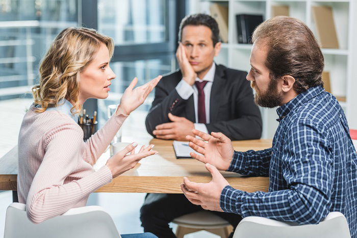 Three people in an office having an argument