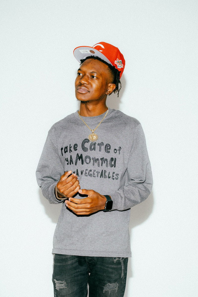 Flash studio portrait of a man in street wear against a white background