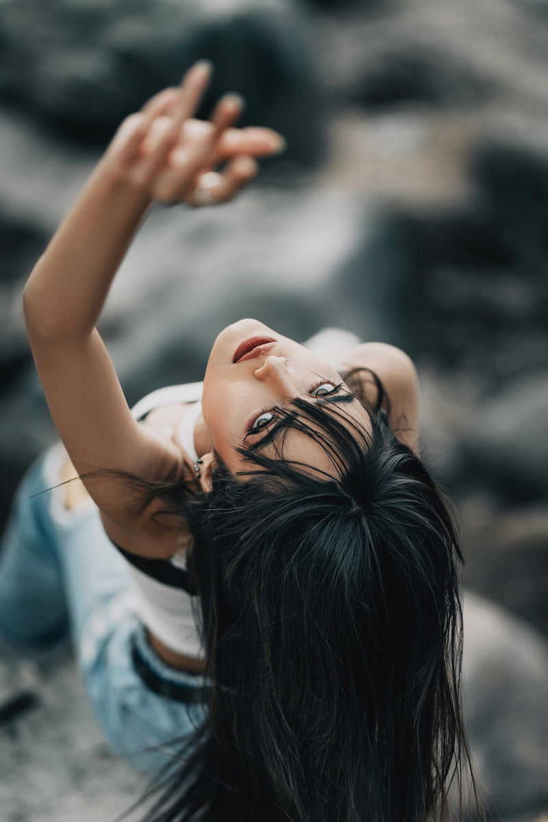 Portrait of a woman bending back with her arms up a shallow depth of field