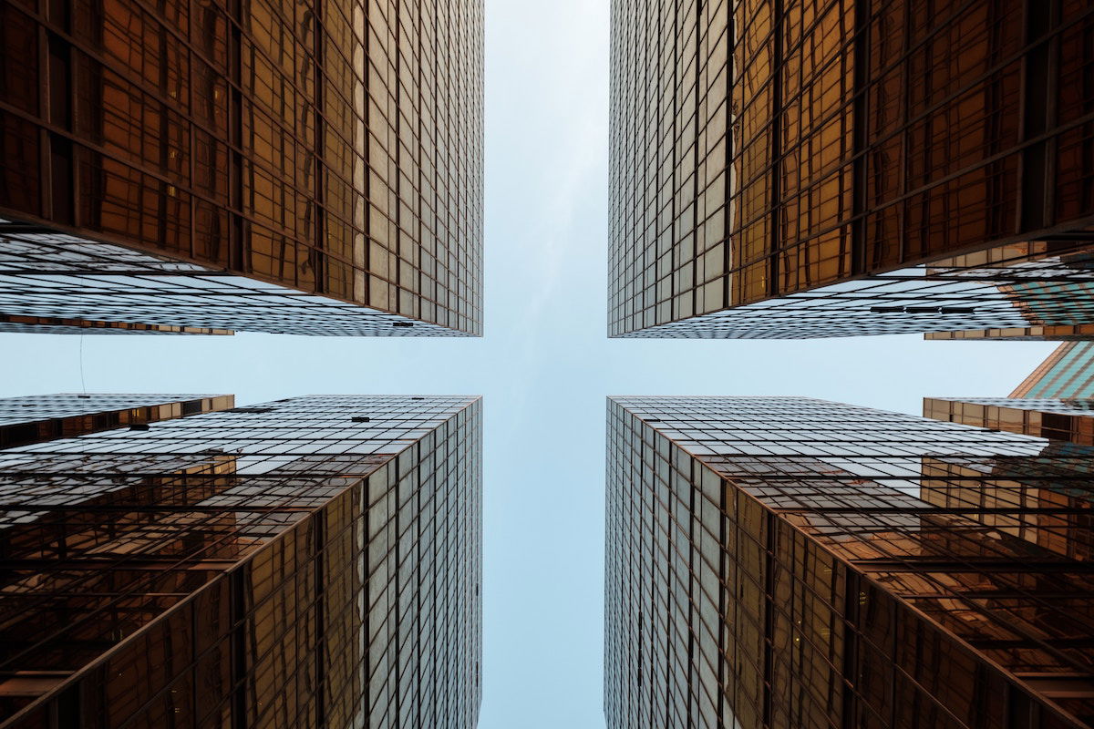 Worm's-eye, symmetrical view looking up at office buildings and the sky