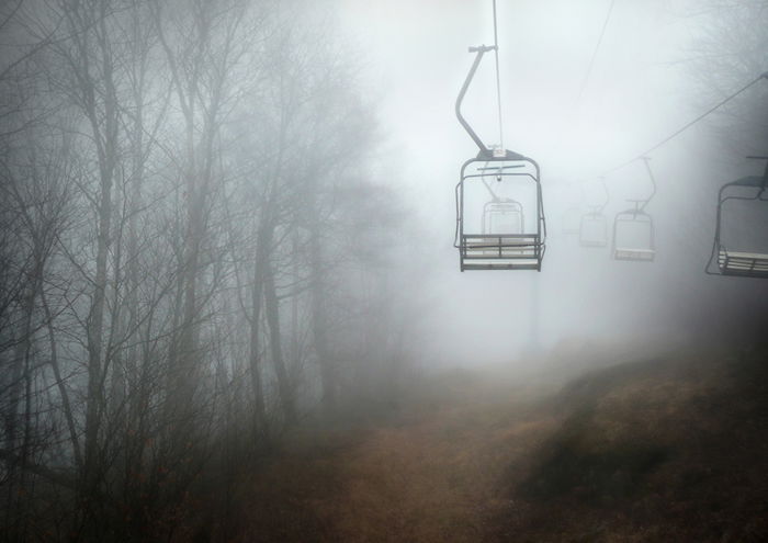 A cablecar is shown in a foggy forest