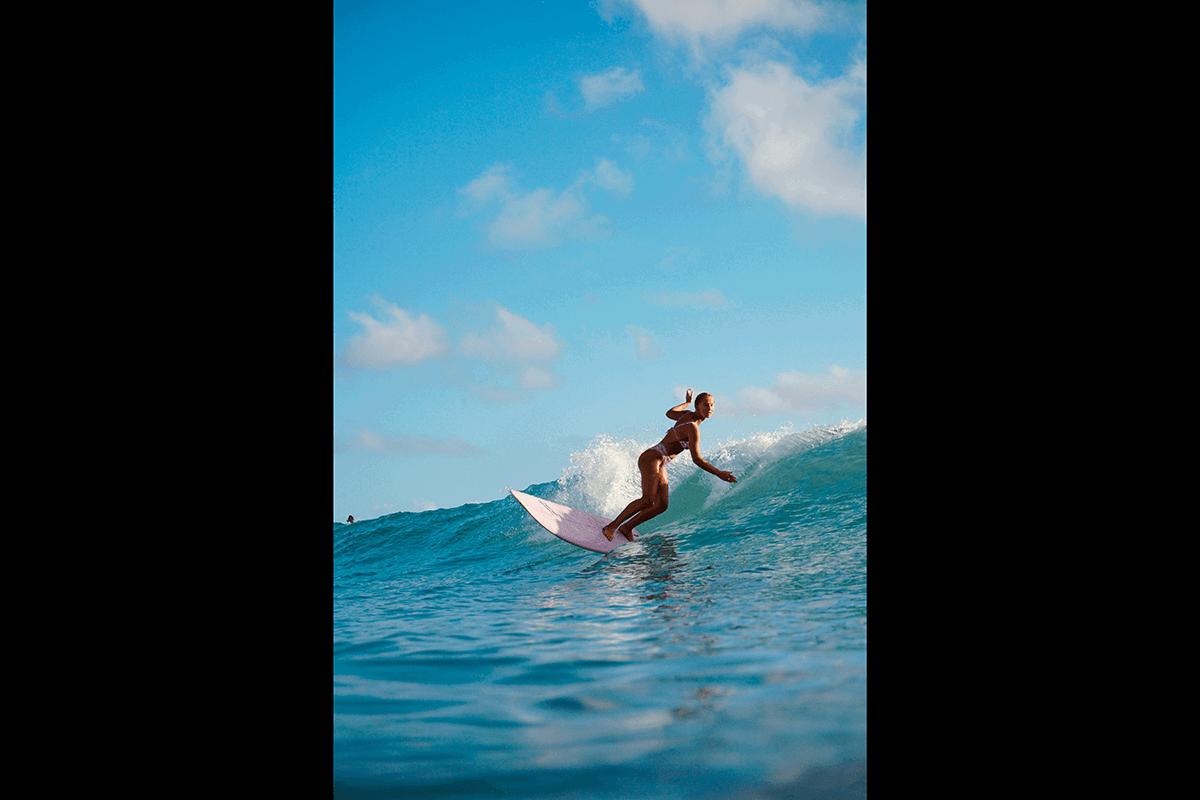 A surfer leaning into a wave under a blue sky as an example of surf photography